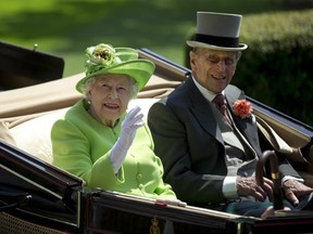 Britain's Queen Elizabeth II, left, waves to the crowd with Prince Philip at right, as they arrive by open carriage to the parade ring on the first day of the Royal Ascot horse race meeting in Ascot, England, Tuesday, June 20, 2017. (AP Photo/Alastair Grant)
