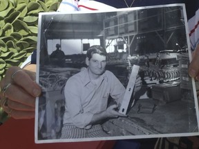 In this May 24, 2017 photo, retired General Electric employee Marilyn Harding shows a photo of her late husband Gerry who died of pancreatic cancer in 2010, five years after retiring from a three-decade career at GE, during an interview at her home in Peterborough, Ontario, Canada. Harding, who spent nearly 40 years working at the plant until she retired in 2004, has also had cancer, as did many of her former colleagues. "Once we got out of there and retired, everyone started to get sick," she said.