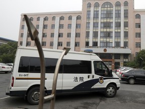 A court van drives into the compound of the Baoshan District People's Court in Shanghai, China, Monday, June 26, 2017. The trial opened Monday of Australian and Chinese casino employees charged with offenses relating to gambling, in a case that highlights the sensitivity of doing certain businesses in China. (AP Photo/Andy Wong)