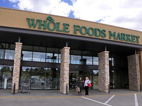 In this May 3, 2017, photo, people stand outside a Whole Foods Market in Upper Saint Clair, Pa. Amazon's planned $13.7 billion acquisition of Whole Foods signals a massive bet that people will opt more for the convenience of online orders and delivery or in-store pickup, putting even more pressure on the already highly competitive industry. (AP Photo/Gene J. Puskar)