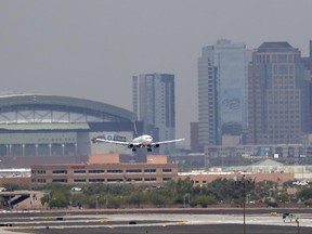 Heat waves ripple across the tarmac at Sky Harbor International Airport as downtown Phoenix stands in the background as an airplane lands, Tuesday, June 20, 2017 in Phoenix. Phoenix hit a high of 118 on Monday with an excessive heat warning in place until Saturday. (AP Photo/Matt York)