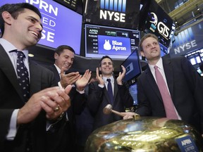 Blue Apron CEO Matt Salzberg, right, with fellow company co-founders Ilia Papas, left, and Matt Wadiak, second from right, rings a ceremonial bell on the New York Stock Exchange floor as their IPO begins trading, Thursday, June 29, 2017. NYSE President Tom Farley is second from left. (AP Photo/Richard Drew)