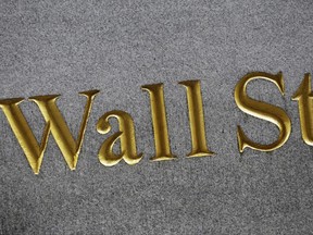 FILE - This Monday, July 6, 2015, file photo shows a sign for Wall Street carved into the side of a building in New York. Stocks are opening slightly higher on Wall Street, Wednesday, June 21, 2017, led by gains in health care and technology companies. The price of crude oil was stable after taking a plunge a day earlier. (AP Photo/Mark Lennihan, File)