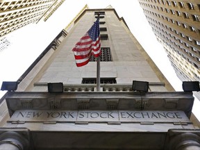 FILE - In this Friday, Nov. 13, 2015, file photo, the American flag flies above the Wall Street entrance to the New York Stock Exchange. U.S. stock indexes edged higher in morning trading Friday, June 30, 2017, recovering some of their losses from a day earlier. (AP Photo/Richard Drew, File)