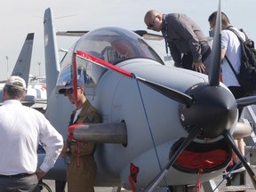 Visitors looks into a Diamond DART 450, a two-seat civilian and military turboprop trainer built by Austrian Diamond Aircraft, at Paris Air Show, in Le Bourget, east of Paris, France, Tuesday, June 20, 2017 in Paris. Aviation professionals and spectators are expected at this week's Paris Air Show, coming in, in a thousands from around the world to make business deals. (AP Photo/Michel Euler)