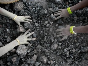 FILE - In this Monday, Dec. 14, 2015, file photo, Indian women use bare hands to pick reusable pieces from heaps of used coal discarded by a carbon factory in Gauhati, India. The world's biggest coal users - China, the United States and India - have boosted coal mining in 2017, in an abrupt departure from last year's record global decline for the heavily polluting fuel and a setback to efforts to rein in climate change emissions. (AP Photo/ Anupam Nath, File)