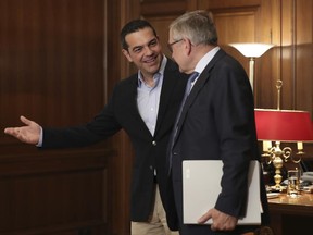 Greek Prime Minister Alexis Tsipras, left, gestures to Managing Director of the European Stability Mechanism Klaus Regling, during their meeting in Athens, on Wednesday, June 28, 2017. (AP Photo/Petros Giannakouris)