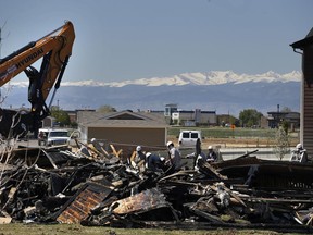 FILE - In this May 4, 2017, file photo, workers dismantle the charred remains of a house at the location where an unrefined petroleum industry gas line leak explosion killed two people inside their home in Firestone, Colo. Fire officials said that an investigation has revealed that the April 17, 2017 explosion was caused by unrefined natural gas that was leaking from a small abandoned pipeline from a nearby well. Energy companies are reporting they have nearly 129,000 underground oil and gas pipelines within 1,000 feet of occupied buildings in Colorado. Friday, June 30, 2017, is the deadline for companies to test those lines for leaks, and about 9,500 results were available at mid-day, with the vast majority indicating the pipelines passed the test.(AP Photo/Brennan Linsley, File)