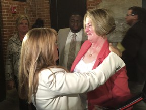 Illinois Senate Minority Leader Christine Radogno, R-Lemont, right, is congratulated by Sen. Melinda Bush, D-Grayslake after a news conference in Springfield, Ill., where Radogno announced that she would she will step down as senator on Saturday, which is first day of the new fiscal year. Lawmakers are working to avoid starting a third consecutive fiscal year without an annual spending plan. (AP Photo by John O'Connor)