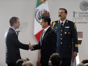 FILE - In this Sept. 2, 2013 file photo, Mexico's President Enrique Pena Nieto, center, shakes hands with the president of the Lower House, Ricardo Anaya Cortez, prior to delivering his first state-of-the-nation address at Los Pinos presidential residence in Mexico City. On Thursday, June 29 2017, internet watchdog Citizen Lab released a research note saying it had determined that the mobile phones of the PAN party president Ricardo Anaya, its chief spokesman, and the party's leader in the Senate, were all sent text messages containing links to the same malware designed to spy on them. (AP Photo/Dario Lopez-Mills, File)