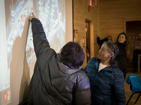 Elders point out map additions and edits during a workshop in the Inuit community of Sanikiluaq as Google's Raleigh Seamster watches.