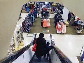 In this March 22, 2017, photo, a woman and child ride the escalator at a Sears store in St. Paul, Minn. In a government filing Friday, June 23, 2017, real estate investment trust Seritage confirmed that Sears Holdings Corp. is closing another 20 stores, two of which are Kmart stores, as the ailing retailer tries to turn around its business. (AP Photo/Jim Mone)