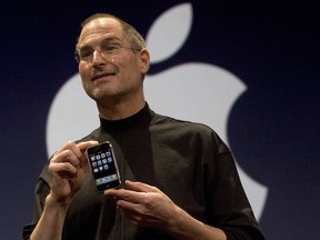 Apple CEO Steve Jobs holds up the new iPhone that was introduced at Macworld on January 9, 2007 in San Francisco, California. The iPhones began shipping that June.