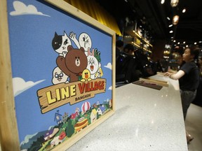 A Thai customer purchases merchandise at the Line Village Bangkok, Thailand, Thursday, June 22, 2017. Thailand's most popular text-messaging service will open its doors to the public Friday an extravagant digital theme park called Line Village Bangkok. (AP Photo/Sakchai Lalit)