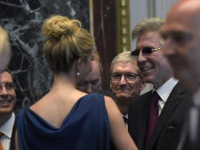 Apple Chief Executive Officer Tim Cook, center, listens as Ivanka Trump talks with Bill McDermott, CEO of German software giant SAP, second from right, follow remarks at the opening session of the White House meeting with technology Chief Executive Officers to mark "technology week," Monday, June 19, 2017, in the Indian Treat Room of the Eisenhower Executive Office Building on the White House complex in Washington. The White House Office of American Innovation is hosting a series of working sessions to generate ideas to transform and modernize Government Services. (AP Photo/Susan Walsh)