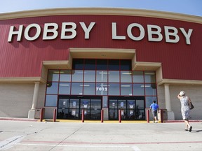 FILE - In this June 30, 2014, file photo, customers walk to a Hobby Lobby store in Oklahoma City. Federal prosecutors say Hobby Lobby Stores has agreed to pay a $3 million federal fine and forfeit thousands of ancient Iraqi artifacts smuggled from the Middle East that the government alleges were intentionally mislabled. Prosecutors filed a civil complaint in New York on Wednesday, July 5, 2017, in which Oklahoma City-based Hobby Lobby consented to the fine and forfeiture of thousands of tablets and bricks written in cuneiform, one of the earliest systems of writing, as well as other artifacts that prosecutors say were shipped without proper documentation. (AP Photo/Sue Ogrocki, File)