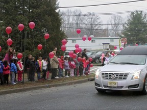 FILE - In this Friday, April 10, 2015, file photo, elementary school students release pink balloons for a classmate who died as her hearse drove past in Wayne, N.J. Efforts to ban balloon launches are facing fierce opposition from The Balloon Council. The council said educating consumers is better than having the "balloon police" ban launches. But critics said the balloons are litter that poses a deadly threat to marine life, birds and other animals and hazards to power lines. (Brian Hester/The Record via AP)