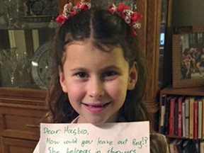 In this January 2016 photo provided by Carrie Goldman, her daughter, Annie Rose, holds a letter in Evanston, Ill., that she wrote to Hasbro asking why the female character Rey was omitted from a Monopoly set based on "Star Wars: The Force Awakens," when she is a main character and crucial to the story. Hasbro responded that they would add Rey to a Star Wars version of Monopoly by the end of the year. Eighteen months later, Annie Rose and others are still waiting. (Carrie Goldman via AP)
