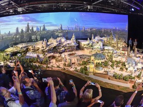 Members of the media get their first look at a 50-foot, detailed model of "Star Wars" land during a media preview for Disney's D23 Expo in Anaheim, Calf., on Thursday, July 13, 2017. (Jeff Gritchen/The Orange County Register via AP)