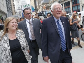 FILE - In this July 28, 2016 file photo, Sen. Bernie Sanders, I-Vt., center right, and his wife Jane, left, walk through downtown in Philadelphia, during the final day of the Democratic National Convention. A Vermont building that housed a now-defunct college where Sen. Sanders' wife was president has been sold at auction. The Burlington Free Press reports People's United Bank took ownership of the former Burlington College property Wednesday, July 12, 2017, for $3.1 million. (AP Photo/John Minchillo, File)