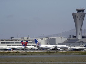 Departing and parked aircraft intersect at San Francisco International Airport, Tuesday, July 11, 2017, in San Francisco. An Air Canada Airbus A320 was cleared to land on one of the runways at the San Francisco airport just before midnight on Friday, July 7,  when the pilot "inadvertently" lined up with the taxiway, which runs parallel to the runway. There were other aircraft lined up on the taxiway waiting for departure when the incident occurred. (AP Photo/Marcio Jose Sanchez)