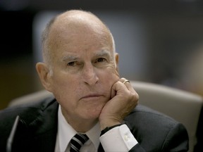 FILE - In this July 13, 2017 file photo, Calif., Gov. Jerry Brown listens as members of the Senate Environmental Quality Committee discuss a pair of climate change bills he supports, in Sacramento, Calif. California lawmakers are nearing a high-stakes decision that will decide the fate of a climate initiative that Brown holds up as a model to be replicated around the world to confront rising global temperatures. A vote is set for Monday on whether to give another decade of life to California's cap-and-trade program. (AP Photo/Rich Pedroncelli, File)
