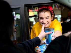 Country music singer Tenille serves up a coffee to driver Sonya Auger while manning the Tim Hortons drive-thru in Grande Prairie, Alberta for the restaurant's Camp Day event last year. Proceeds from every coffee sold on Camp Day go to Tom Hortons camps so kids, who may not otherwise get to go, have the opportunity to have fun at camp.