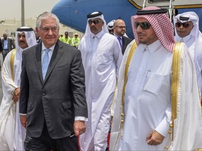 In this photo released by Qatar News Agency, U.S. Secretary of State Rex Tillerson arrives in Doha, Qatar, Tuesday, July 11, 2017. Tillerson arrived in Qatar as he tries to mediate a dispute between the energy-rich country and its Gulf neighbors. The visit is Tillerson's second stop on a shuttle-diplomacy tour that is also expected to take him to Saudi Arabia, which shares Qatar's only land border and is the most powerful of the four countries lined up against it. (Qatar News Agency via AP)