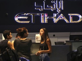 Passengers check into a flight at Abu Dhabi International Airport in Abu Dhabi, United Arab Emirates, Tuesday, July 4, 2017.  Travelers bound for the U.S. now enjoy something many others flying out of the Middle East can't _ walking onto an airplane with their laptop. But what has changed in Abu Dhabi remains unclear as the laptop ban still affects nine other regional airports, including the world's busiest for international travel in nearby Dubai. (AP Photo/Jon Gambrell)