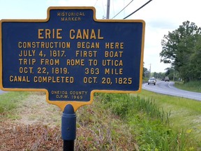 In this June 28, 2017, photo, a sign on route 49/46 in Rome, N.Y., marks the spot where digging for construction on the Erie Canal began. This Fourth of July marks the 200th anniversary of the ceremonial first digging for the construction of the Erie Canal, a 363-mile waterway that would change history. (John Clifford/The Daily Sentinel via AP)