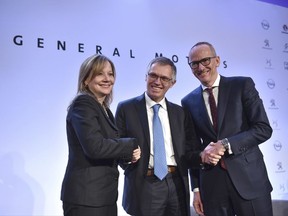 FILE - In this March 6, 2017 file photo CEO of PSA Carlos Tavares, Opel CEO Karl-Thomas Neumann, right, and GM CEO Mary Barra, left, pose for photographers after addressing the media in Paris, France. On Wednesday, July 5, 2017 the European Union has approved French automaker PSA's acquisition of Opel and British brand Vauxhall from General Motors. The EU's executive Commission said it has given unconditional approval to the deal. (AP Photo/Zacharie Scheurer, file)
