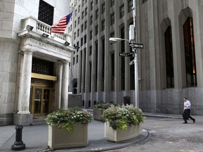 FILE - In this Monday, Aug. 24, 2015, file photo, a man walks towards the New York Stock Exchange. U.S. stocks are rising, Monday, July 3, 2017, as banks like Wells Fargo and Morgan Stanley make gains. Automakers are mostly higher as they start to report their monthly sales totals. Bankrate jumped after it agreed to be acquired by Red Ventures. (AP Photo/Seth Wenig, File)