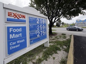 In this Wednesday, July 19, 2017, photo, a motorist drives by an Exxon sign displaying gas prices in Opa-locka, Fla. Exxon Mobil Corp. reports earnings, Friday, July 28, 2017. (AP Photo/Alan Diaz)