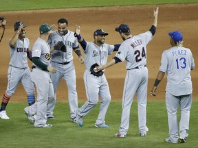 FILE - In this July 11, 2017 photo, American League teammates celebrate winning the MLB baseball All-Star Game in Miami. The American League defeated the National League 2-1 in ten innings. Seattle Mariners Robinson Cano (22), third from right, hit the game winning home run. (AP Photo/Wilfredo Lee)