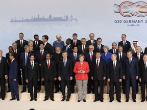 The participants pose for a group photo on the first day of the G-20 summit in Hamburg, northern Germany, Friday, July 7, 2017. The leaders of the group of 20 meet July 7 and 8. (AP Photo/Michael Sohn)