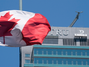 Workers start to take down the letters off a Trump Hotel in Toronto on Tuesday.  JCF Capital ULC, the new owners of Trump International Hotel and Tower, reached a buyout deal with Trump Hotels last month.