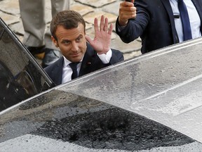 France's President Emmanuel Macron enters in his car after a military ceremony, at the Hotel des Invalides in Paris, Friday, June 30, 2017. (AP Photo/Francois Mori)