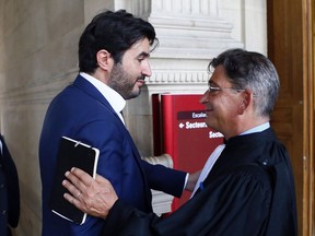 French financier Nadav Bensoussan, left, discusses with his lawyer Jean Marc Fedida as he leaves the Palais de Justice courthouse in Paris, France, after he was sentenced to serve two years in prison, Thursday, July 6, 2017. A Paris court has heavily fined a Latvian bank, Rietumu Banka, for laundering hundreds of millions of euros with the complicity of Nadav Bensoussan, through a vast scheme allowing French taxpayers to evade taxes. (AP Photo/Francois Mori)