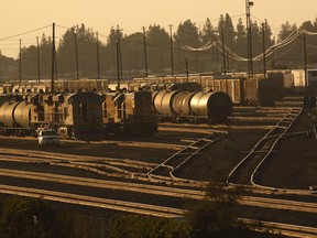In this June 23, 2017 photo, trains are lined up near a section of Highway 99 in Fresno, Calif. California's vast San Joaquin Valley, the country's most productive farming region, is engulfed by some of the nation's dirtiest skies, forcing the state's largest air district to spend more than $40 billion in the past quarter-century to enforce hundreds of stringent pollution rules. The investment has steadily driven down the number of days with unhealthy air - but on hot, windless days, a brown haze still hangs overhead, sending wheezing people with tight chests to emergency rooms and hundreds each year to an early grave.  (AP Photo/Gary Kazanjian)