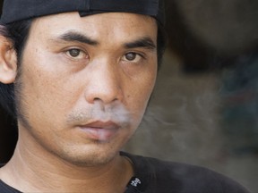 FILE - In this March 22, 2016 file photo, an unidentified foreign fisherman smokes a cigarette aboard a U.S. fishing vessel at Pier 38 in Honolulu. A human rights complaint has been filed on behalf of foreign fishermen working in Hawaii's longline fishing fleet. Turtle Island Restoration Network told The Associated Press on Thursday, July 20, 2017, that they filed the complaint last week with the Inter-American Human Rights Commission. It asks the commission to investigate conditions among foreign workers in the U.S. fishing fleet. The AP reported last year that hundreds of men are confined to Hawaii boats that operate due to a federal loophole that exempts foreign workers from most basic labor protections. The fleet catches $110 million worth of luxury seafood annually. (AP Photo/Caleb Jones, File)