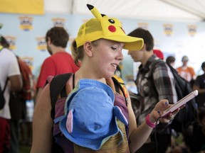 Lauren Schuster of Miami looks at her phone as she struggles to get her Pokemon Go game to quit crashing at the Pokemon Go Fest Saturday, July 22, 2017, at Grant Park in Chicago. Many festival attendees had trouble getting the augmented-reality cellphone game to work. By the afternoon, Mike Quigley, chief marketing officer of the game's developer, Niantic, announced all ticket holders would receive refunds and be issued $100 in credits for use in the app. Schuster and a group of others came to Chicago just for the event. (Erin Hooley/Chicago Tribune via AP)