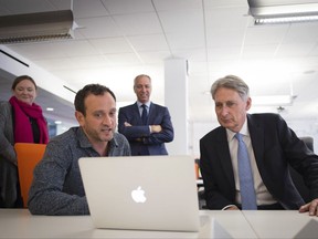 Britain's Chancellor of the Exchequer, Philip Hammond, right, meets staff as he tours the IBM office on South Bank, London, as the preliminary estimates for 2017 Q2 GDP are published, Wednesday July 26, 2017. The economy grew by a quarterly rate of 0.3 percent in April-June, a meager rate that is barely above the 0.2 percent of the first three months of the year, the Office of National Statistics said Wednesday. (Stefan Rousseau/Pool Photo via AP)