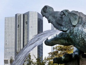 FILE - In this Oct. 11, 2016 file photo water spills out of a small dragon sculpture on a fountain with the headquarters of the Deutsche Bank in background in Frankfurt, Germany. Deutsche Bank announces its second-quarter earnings on Thursday, July 27, 2017. (AP Photo/Michael Probst, file)