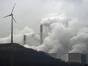 FILE - In this file photo dated Monday, Dec. 1, 2014, a wind turbine overlooks the coal-fired power station in Gelsenkirchen, Germany.  The European Environment Agency released a report late Sunday July 9, 2017, saying coal-fired power plants are responsible for the most water and air pollution on the European continent, with Britain among the top polluters, followed by Germany, France and Poland. (AP Photo/Martin Meissner, FILE)