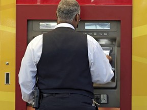 In this Thursday, April 13, 2017, photo, a man uses a Wells Fargo ATM in Charlotte, N.C. Wells Fargo & Co. reports earnings, Friday, July 14, 2017. (AP Photo/Chuck Burton)