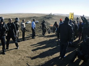 FILE - In this Nov. 11, 2016, file photo, law enforcement try to move Dakota Access pipeline protesters further down during a protest at a pipeline construction site south of St. Anthony, N.D. The Trump administration has denied a request from Republican North Dakota Gov. Doug Burgum for a "major disaster declaration" to help cover some of the estimated $38 million cost to police protests of the pipeline. (Mike McCleary/The Bismarck Tribune via AP, File)