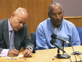 Former NFL football star O.J. Simpson, right,  reacts after learning he was granted parole at Lovelock Correctional Center in Lovelock, Nev., on Thursday, July 20, 2017.  Simpson was convicted in 2008 of enlisting some men he barely knew, including two who had guns, to retrieve from two sports collectibles sellers some items that Simpson said were stolen from him a decade earlier.   (Jason Bean/The Reno Gazette-Journal via AP, Pool)