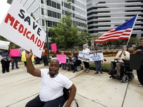 Mario Henderson leads chants of "save Medicaid," as other social service activists, Medicaid recipients and their supporters stage a protest outside the building that houses the offices of U.S. Sen. Thad Cochran, R-Miss., Thursday, June 29, 2017, in Jackson, Miss. Soaring prices and fewer choices may greet customers when they return to the Affordable Care Act's insurance marketplaces in the fall of 2017, in part because insurers are facing deep uncertainty about whether the Trump administration will continue to make key subsidy payments and enforce other parts of the existing law that help control prices. (AP Photo/Rogelio V. Solis)
