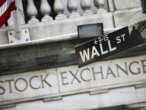 FILE - This July 16, 2013, file photo, shows a Wall Street street sign outside the New York Stock Exchange.  U.S. stocks are falling, Friday, July 21, 2017,  as General Electric stock drops after the company's second-quarter report. Most other industries are also lower, including technology companies, which have soared during a 10-day winning streak.  (AP Photo/Mark Lennihan, File)