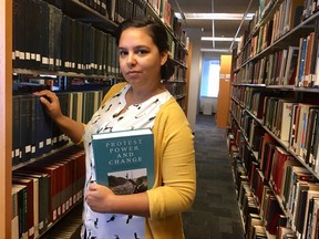 This Tuesday, July 11, 2017 photo shows Alexandra Flores in the Nelson Poynter Memorial Library on the University of South Florida St. Petersburg campus. Flores, 29, works as a library assistant while pursuing a master's degree in library science. She credits the Obama health law for her decision to go back to school rather than be locked into her previous office job. "Without health care, I wouldn't feel comfortable growing my career the way I have," Flores said. (Natalie Polson via AP)
